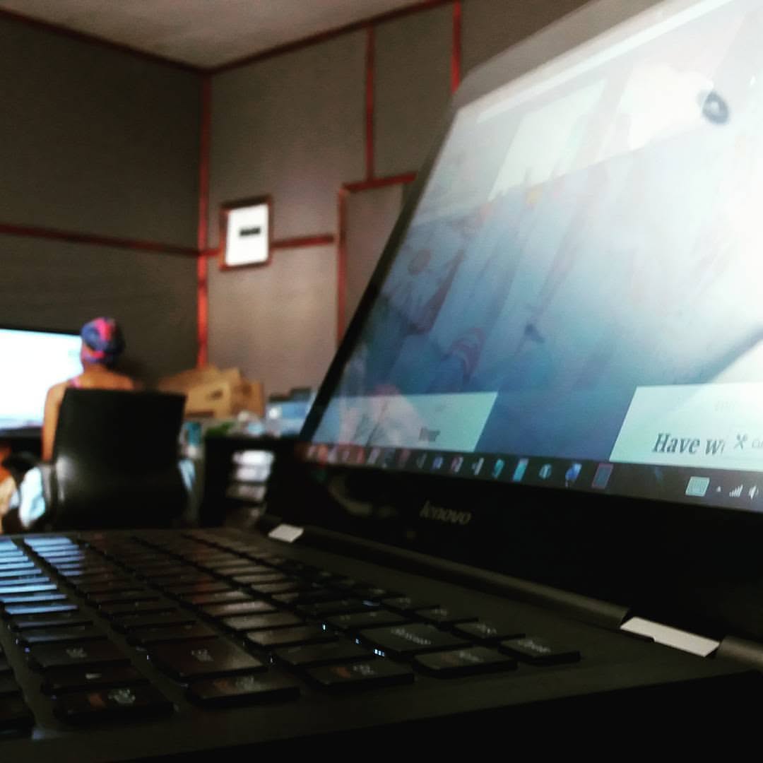 A laptop in a Consensio working environment with a colleague at another screen